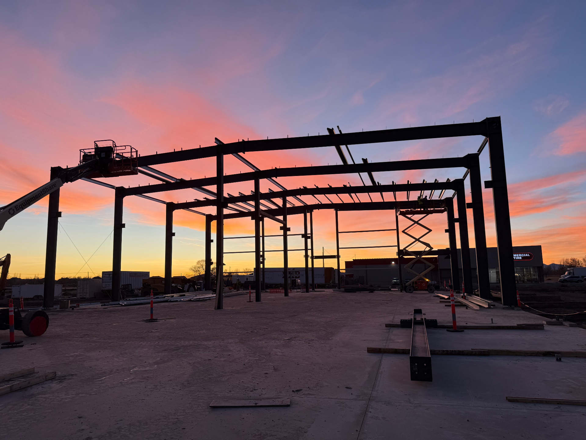 Structural steel frame silhouetted against a sunset sky in West Haven, Utah
